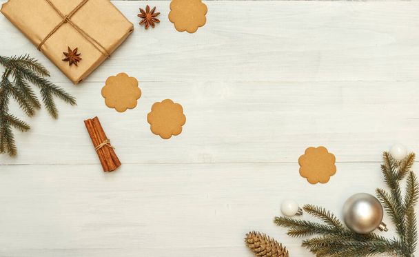Fond de Noël avec branches de sapin, cadeau en papier artisanal, biscuits au gingembre et anis étoilé. Vue de dessus avec espace, sur un fond clair - Photo, image