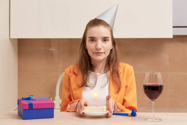 Young beautiful woman holding a birthday cake. Birthday celebration at home. - 写真・画像
