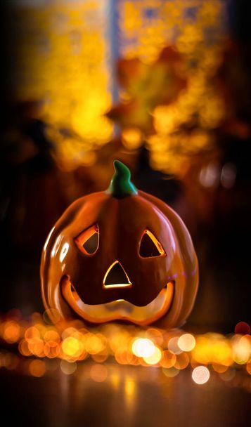 Neon glowing pumpkin head on abstract blurred bokeh background. Festive Halloween background with cobwebs and pumpkin. Blurred background. - Photo, image