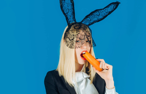 Cute bunny woman. Happy young woman wearing bunny ears and having Easter Eggs. Bunny rabbit eat carrot. - Foto, Imagem