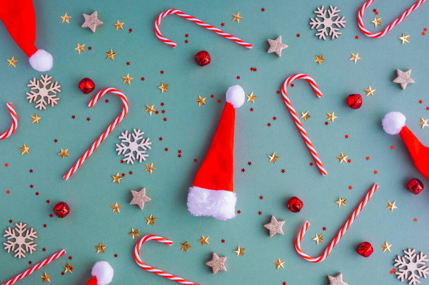 Nový rok nebo vánoční pozadí. Ploché lei z klobouků Santa Claus a vánočních hraček a lízátek. Perfektní řešení pro novoroční přání - Fotografie, Obrázek