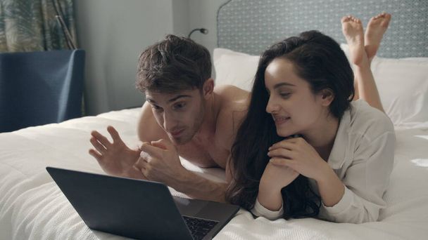Pareja elegante hablando cámara web portátil. Hermosa pareja mirando la pantalla del ordenador - Foto, imagen