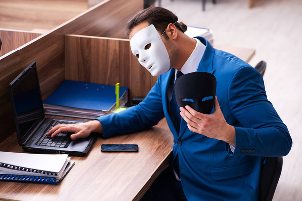 Mladý muž zaměstnanec nosí masku v kanceláři - Fotografie, Obrázek