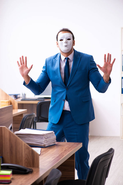 Молодий працівник чоловічої статі в масці в офісі
 - Фото, зображення
