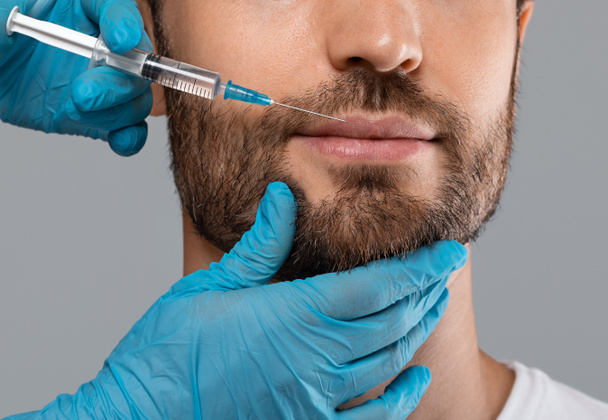Unrecognizable bearded man getting lips filler in beauty salon - Zdjęcie, obraz