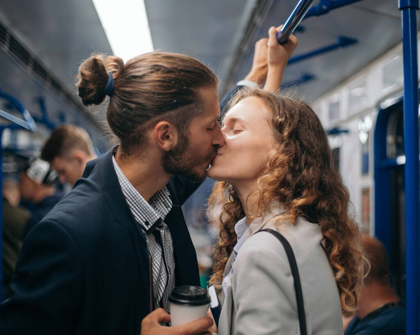 happy kissing couple standing on a subway train. - Fotografie, Obrázek