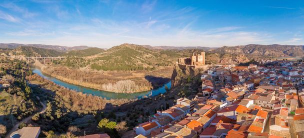 Vista panorámica aérea del castillo medieval parcialmente restaurado de Cofrentes sobre el río Cabriel en España con reflejo y cielo dramático - Foto, Imagen