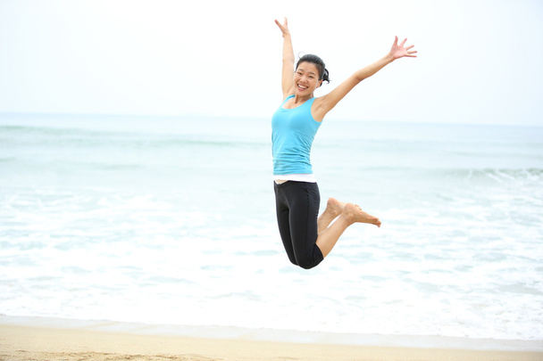 Kumsalda zıplayan mutlu kadın - Fotoğraf, Görsel
