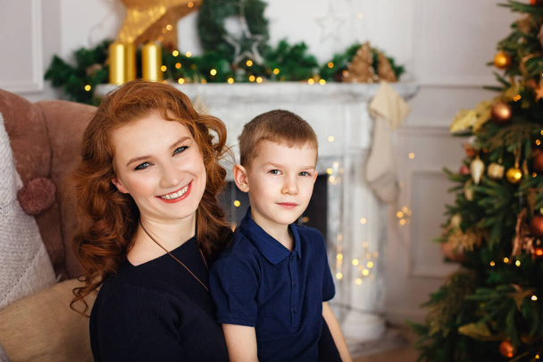 Happy family, mother and son in a room decorated with Christmas decorations, preparing to celebrate the New year - Foto, Imagen