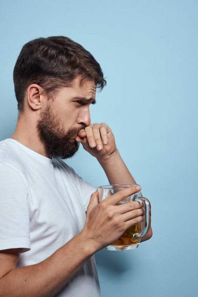 Barbuto uomo birra tazza alcol bianco t-shirt vista laterale sfondo blu - Foto, immagini