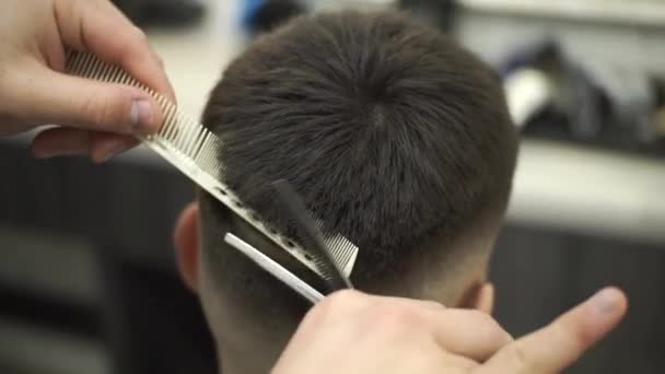 Gros plan, maître coiffeur fait coiffure et style avec ciseaux et peigne. Concept Barbershop. - Séquence, vidéo