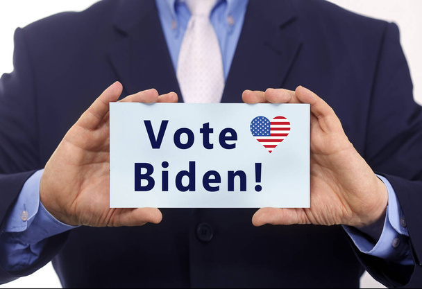 Hombre de negocios mantener el voto en papel Biden texto sobre ella - Foto, imagen