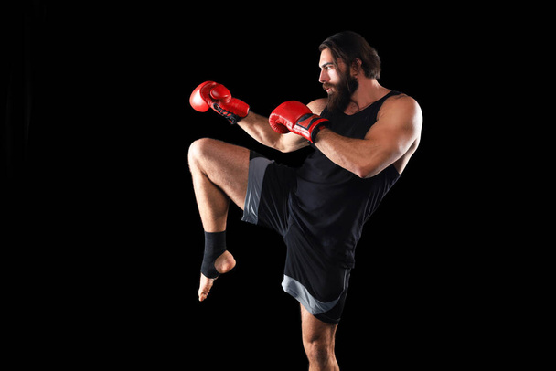 Kickboxer man fighting against black background. Sport concept - Foto, Imagem