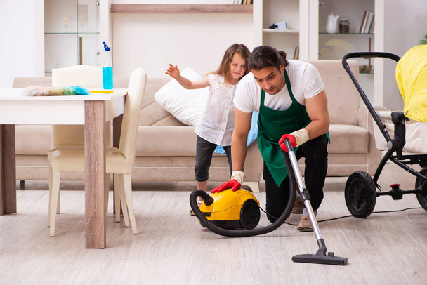 Jovem empreiteiro limpando a casa com sua filha pequena - Foto, Imagem