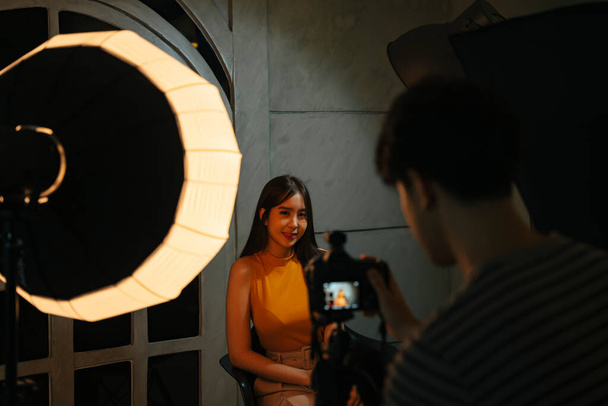 Jeune photographe asiatique un jour de tournage en studio chambre noire avec modèle. - Photo, image
