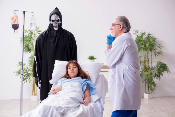 Diablo, viejo doctor y paciente femenino en la clínica - Foto, imagen