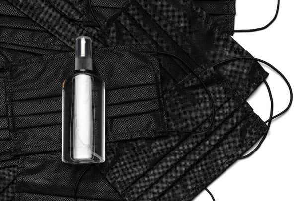 bottle of lotion, sanitizer or liquid soap and medical protective masks over white background - Zdjęcie, obraz
