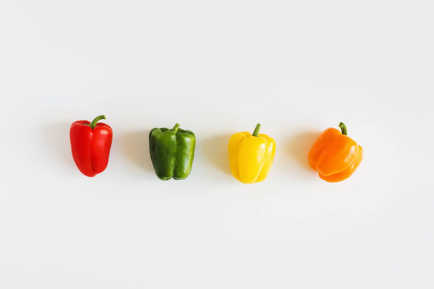 Red, green, yellow and orange bell pepper on white background, top view. flat lay. Capsicum mix - Fotoğraf, Görsel