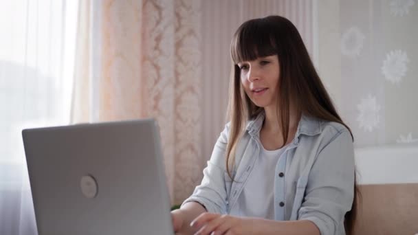 dívka pracuje na počítači objednává produkty z obchodu on-line, zatímco sedí doma - Záběry, video