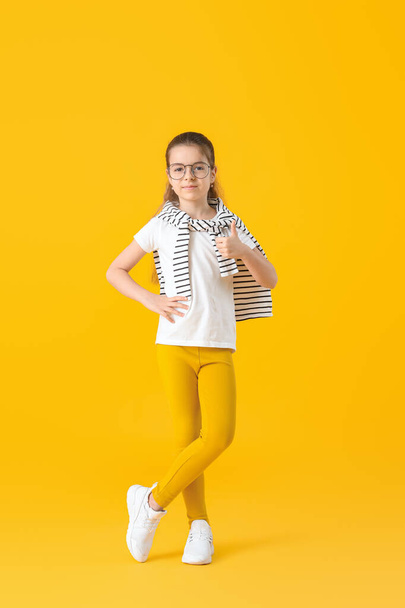 Cute little girl showing thumb-up gesture on color background - Foto, afbeelding