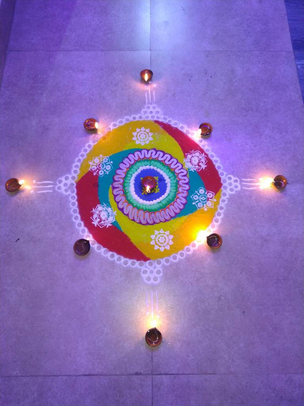 festival indiano diwali rangoli, bonito e colorido, decorado com diyas e irradiando luz azul no fundo, celebração feliz com biscoitos de fogo. - Foto, Imagem
