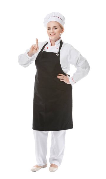 Chef femenino maduro con el dedo índice elevado sobre fondo blanco - Foto, Imagen