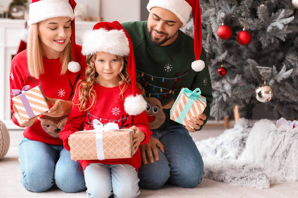 Familia joven con regalos de Navidad en casa - Foto, Imagen