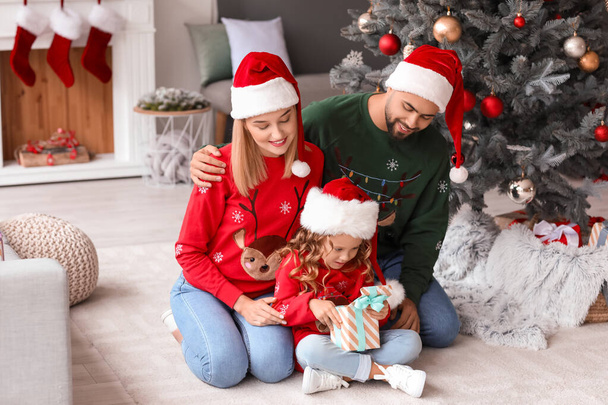 Familia joven con regalo de Navidad en casa - Foto, Imagen