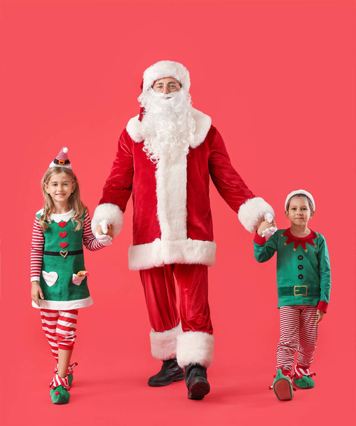 Cute little elves with Santa Claus on color background - Foto, Imagem