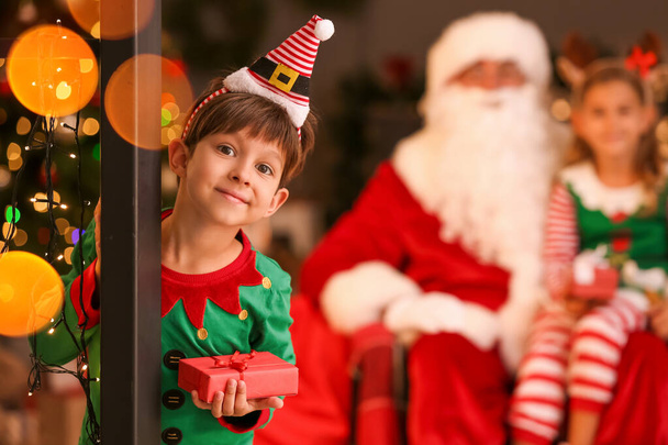 Pequeño elfo lindo con regalo en casa en Nochebuena - Foto, Imagen