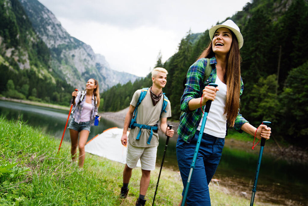 Hiking with friends is so fun. Group of young people with backpacks trekking together - Foto, imagen