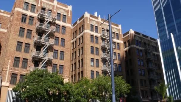 Drabinka przeciwpożarowa przed budynkiem mieszkalnym z cegły w San Diego, USA. Typowe wyjście awaryjne w stylu Nowego Jorku dla bezpiecznej ewakuacji. Klasyczny retro dom zewnętrzny jako symbol nieruchomości - Materiał filmowy, wideo