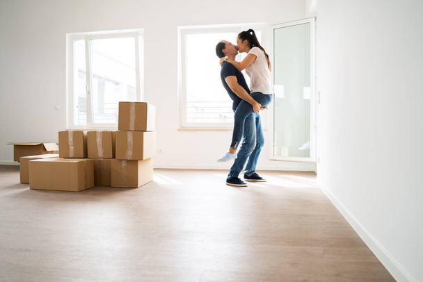 Couple Making Jump And Hug While Moving Boxes - 写真・画像