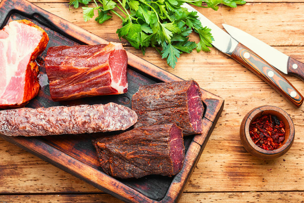Hiszpański talerz mięsny.Mięso peklowane i kiełbaski na desce do krojenia - Zdjęcie, obraz