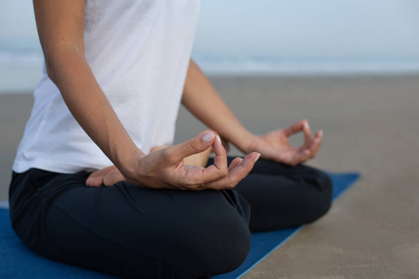 a girl meditates on the beach. hands fingers wise. india - Valokuva, kuva