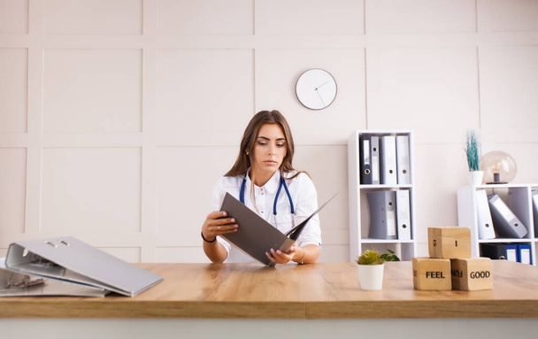 Young female doctor in a white coat in a clinical office. Health care concept. - Foto, Imagen