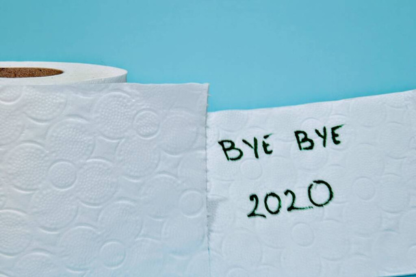 Bye Bye 2020 tuvalet kağıdına mesaj at. Son sayfanın yırtılması. Mavi arkaplan ile izole edilmiş. - Fotoğraf, Görsel