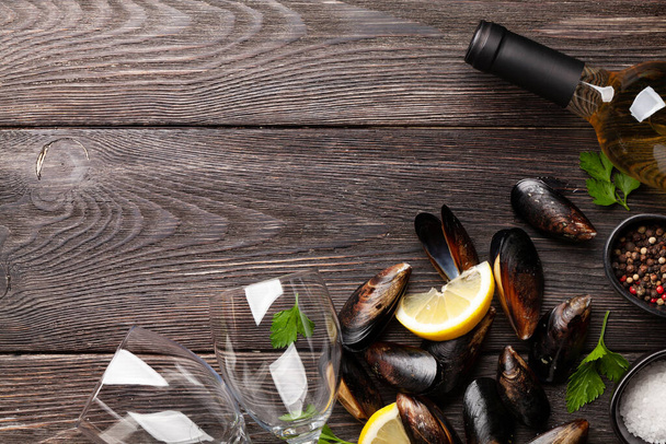 Seafood mussels and white wine on wooden table table. Top view flat lay with copy space - Photo, Image