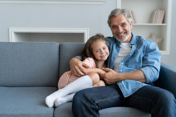 Happy sweet girl hugging her father at home. - Foto, Imagem