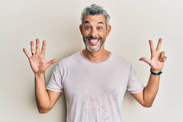 Middle age grey-haired man wearing casual clothes showing and pointing up with fingers number eight while smiling confident and happy.  - Photo, Image