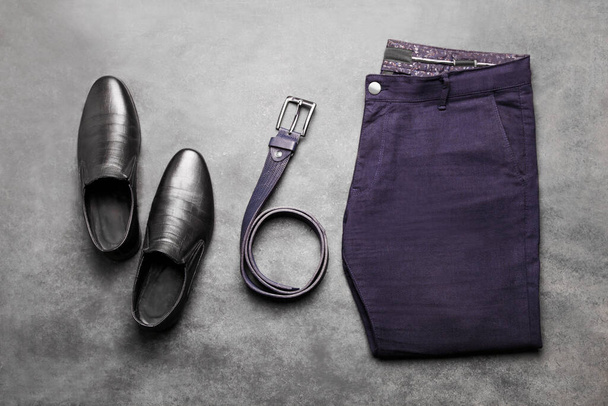 Pantalón clásico azul para hombre con zapatos de cuero negro y cinturón sobre fondo negro. Ropa de hombre. - Foto, imagen