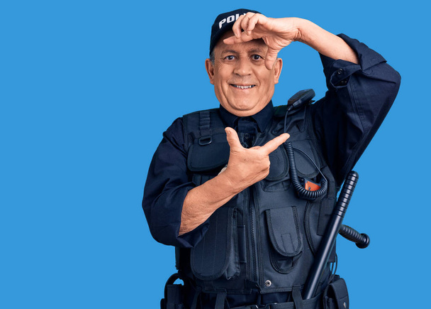 Старший красавчик в полицейской форме улыбается, делая рамку с руками и пальцами со счастливым лицом. креативность и концепция фотографии.  - Фото, изображение