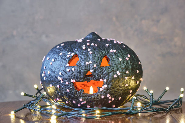 black coloured pumpkin with glitter on wooden stool in front of a brown backdrop - Valokuva, kuva