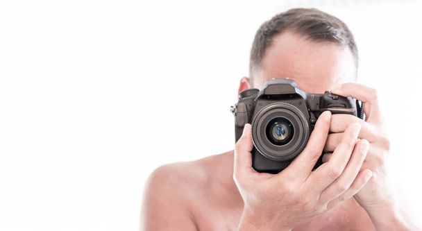 Nahaufnahme eines jungen Mannes, der fokussiert und durch den Sucher seiner Spiegelreflexkamera fotografiert. Kopierraum - Foto, Bild