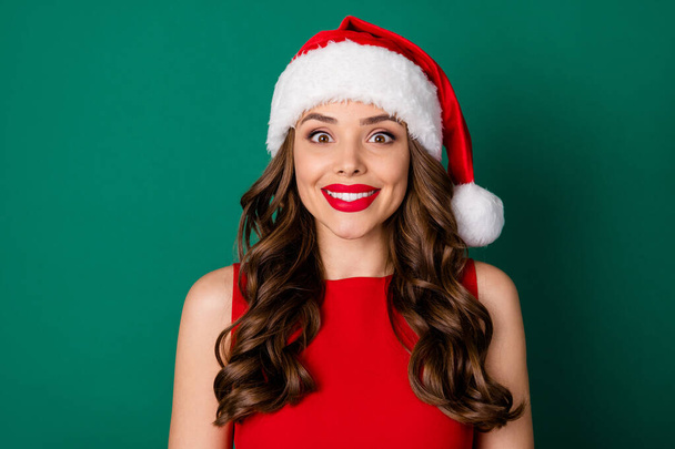 Photo of positive charming nice girl in santa claus red headwear enjoy x-mas holly jolly newyear event wear good look skirt isolated over green color background - Foto, imagen