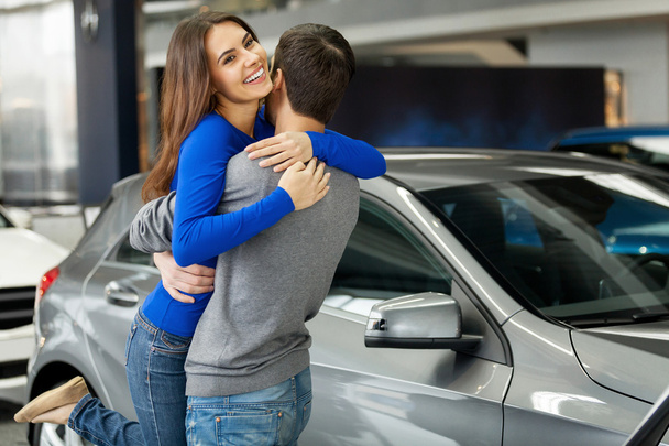 Woman hugging her boyfriend thanks for the new car - Foto, immagini