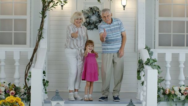 Büyükbaba ve büyükanne çiftin torunları el sallıyor, gülümsüyor ve merhaba diyorlar. - Fotoğraf, Görsel