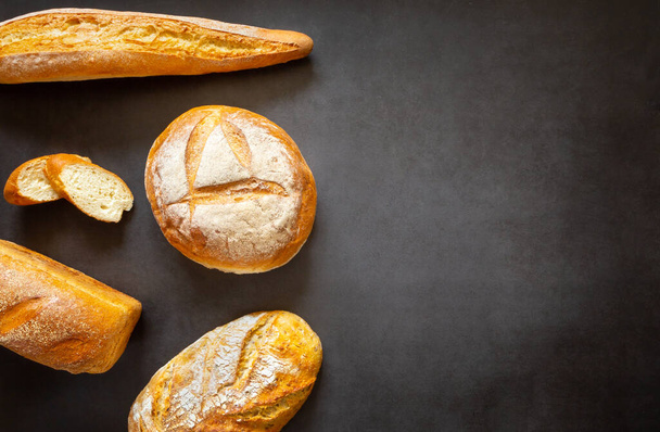 Assorted loaves, baguettes and slices of homemade artisan bread. With copy space  - Foto, imagen
