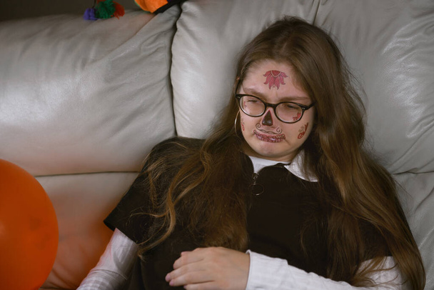 frustrovaná a smutná dívka v halloweenském make-upu sedí na gauči, svátky selhaly. Izolovaný obrázek - Fotografie, Obrázek