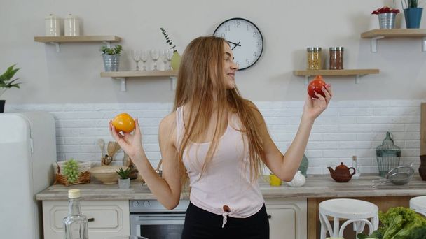 Girl recommending eating raw vegetable food. Showing tomatoes in hands. Weight loss and diet concept - Photo, Image